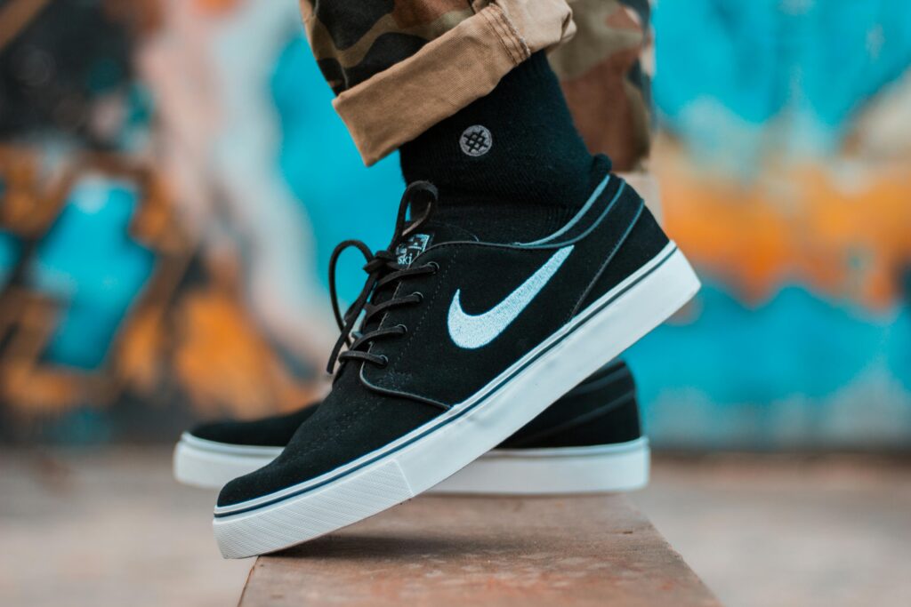 Close-up of black sneakers with camouflage pants, showcasing urban style.